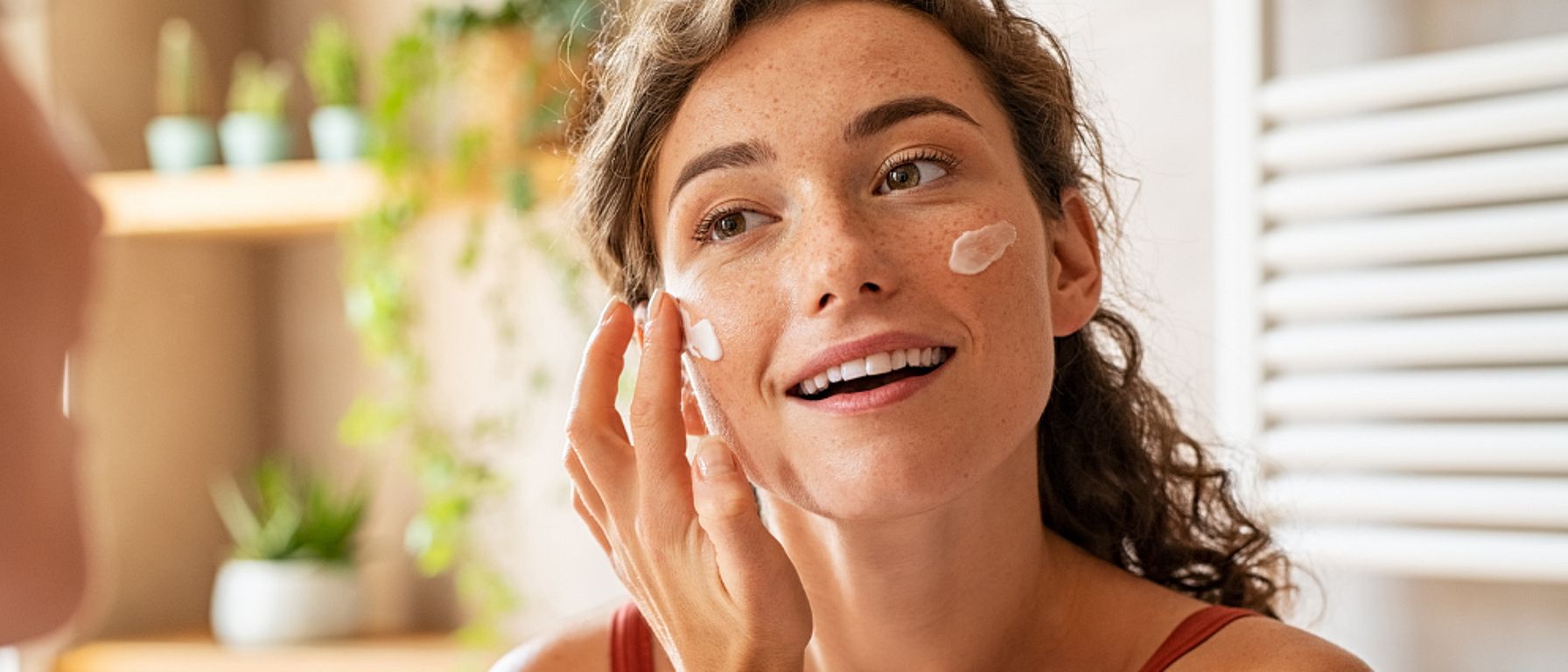 Žena nanáší krém na obličej