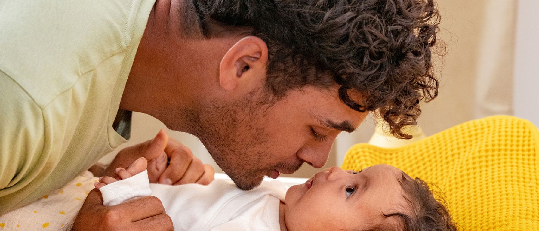Otec se láskyplně tulí k miminku