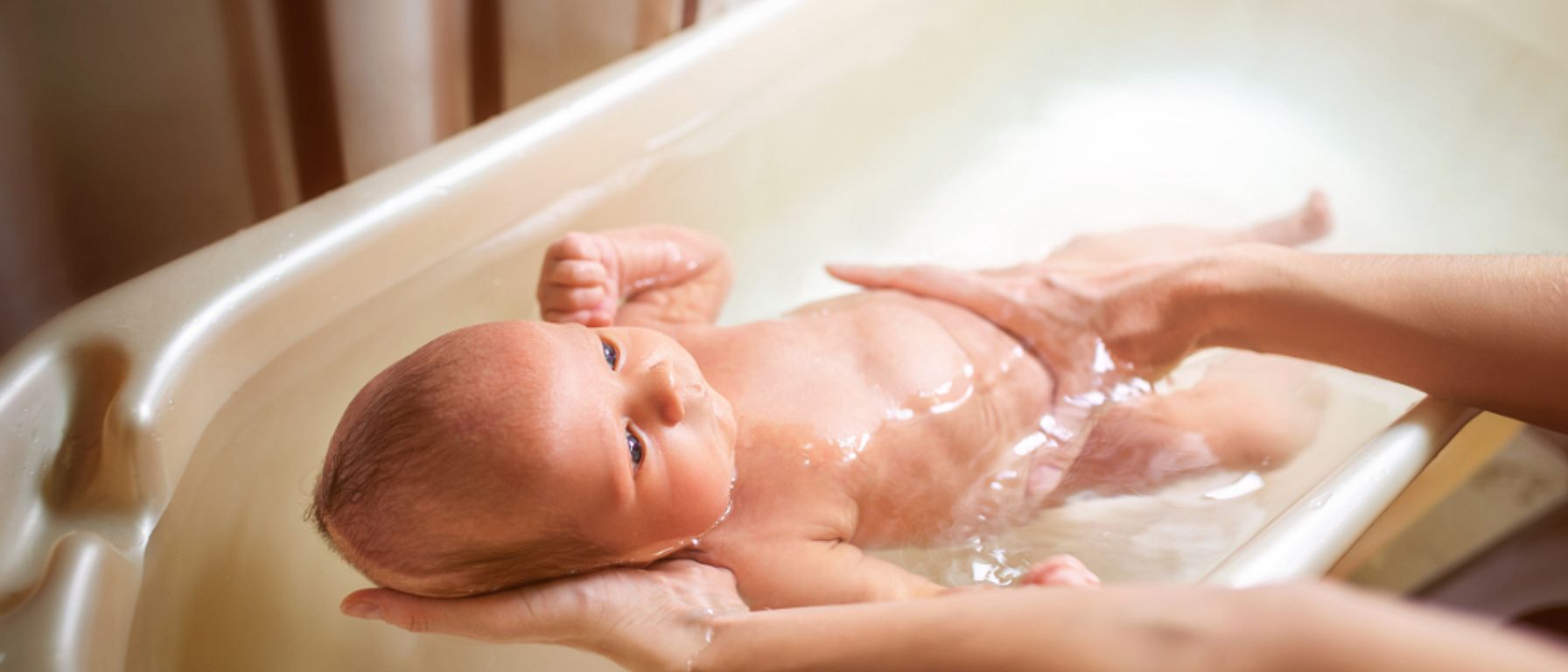 rodič koupe miminko ve vaničce