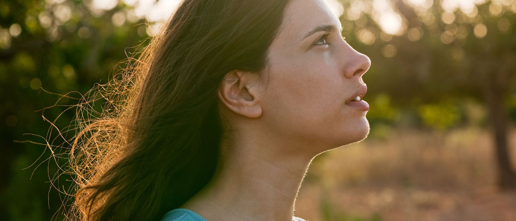 žena se dívá na západ slunce