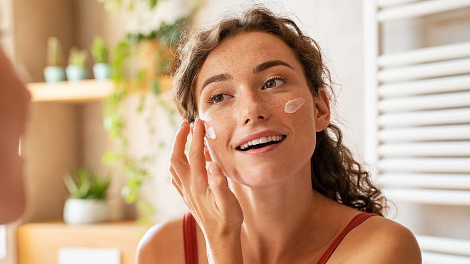 Žena nanáší krém na obličej