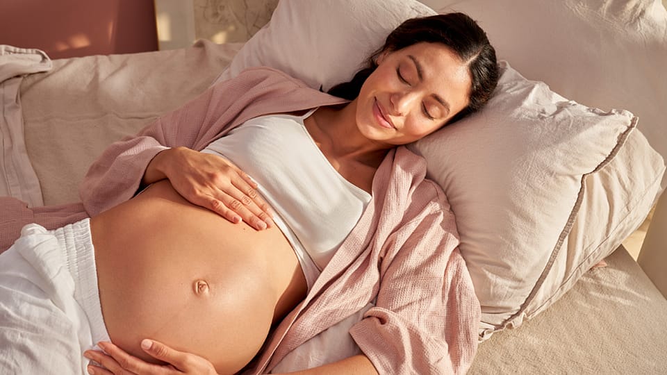 těhotná žena ležící v posteli