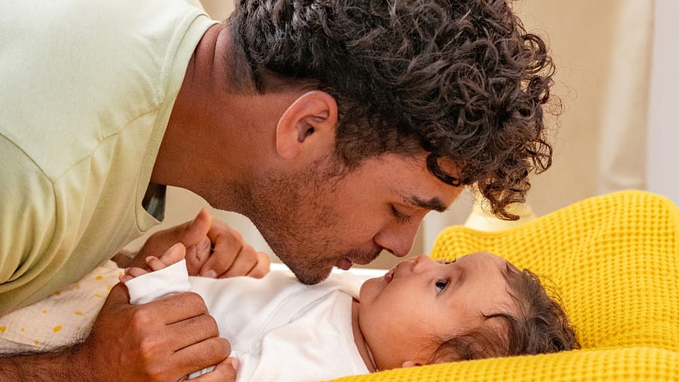 Otec se láskyplně tulí k miminku