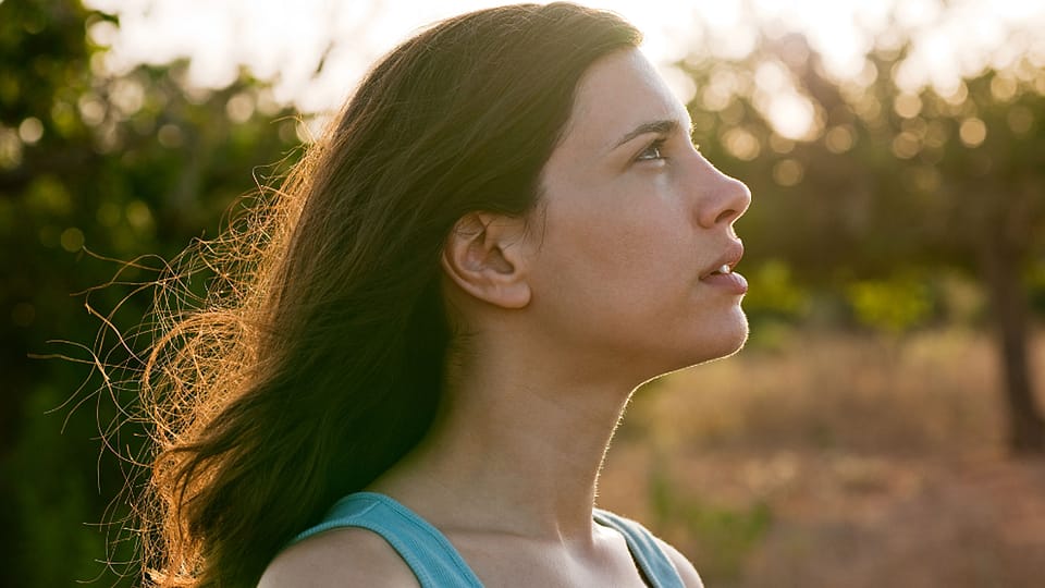 žena se dívá na západ slunce