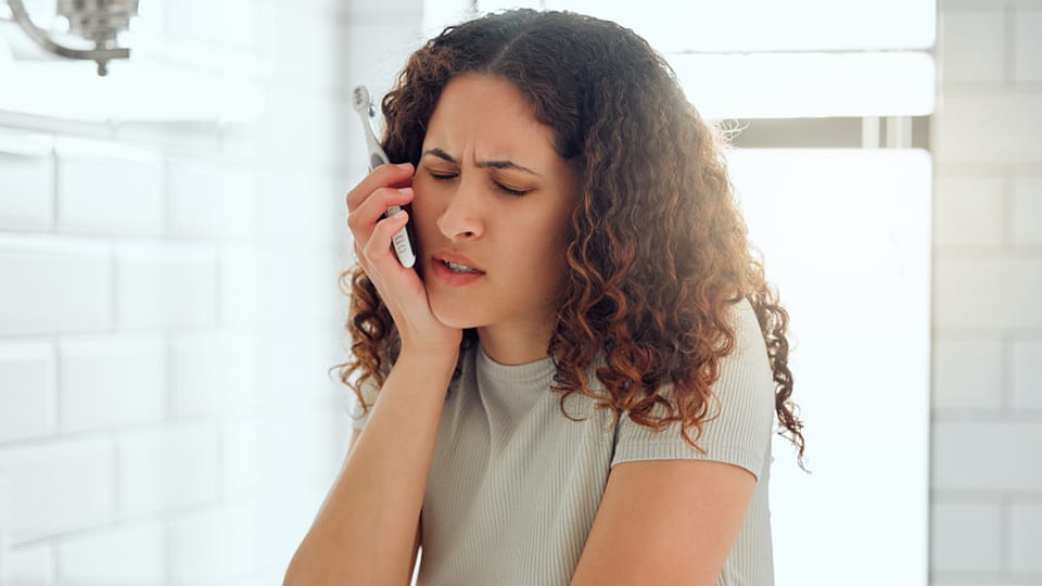 žena v koupelně s bolestí zubů