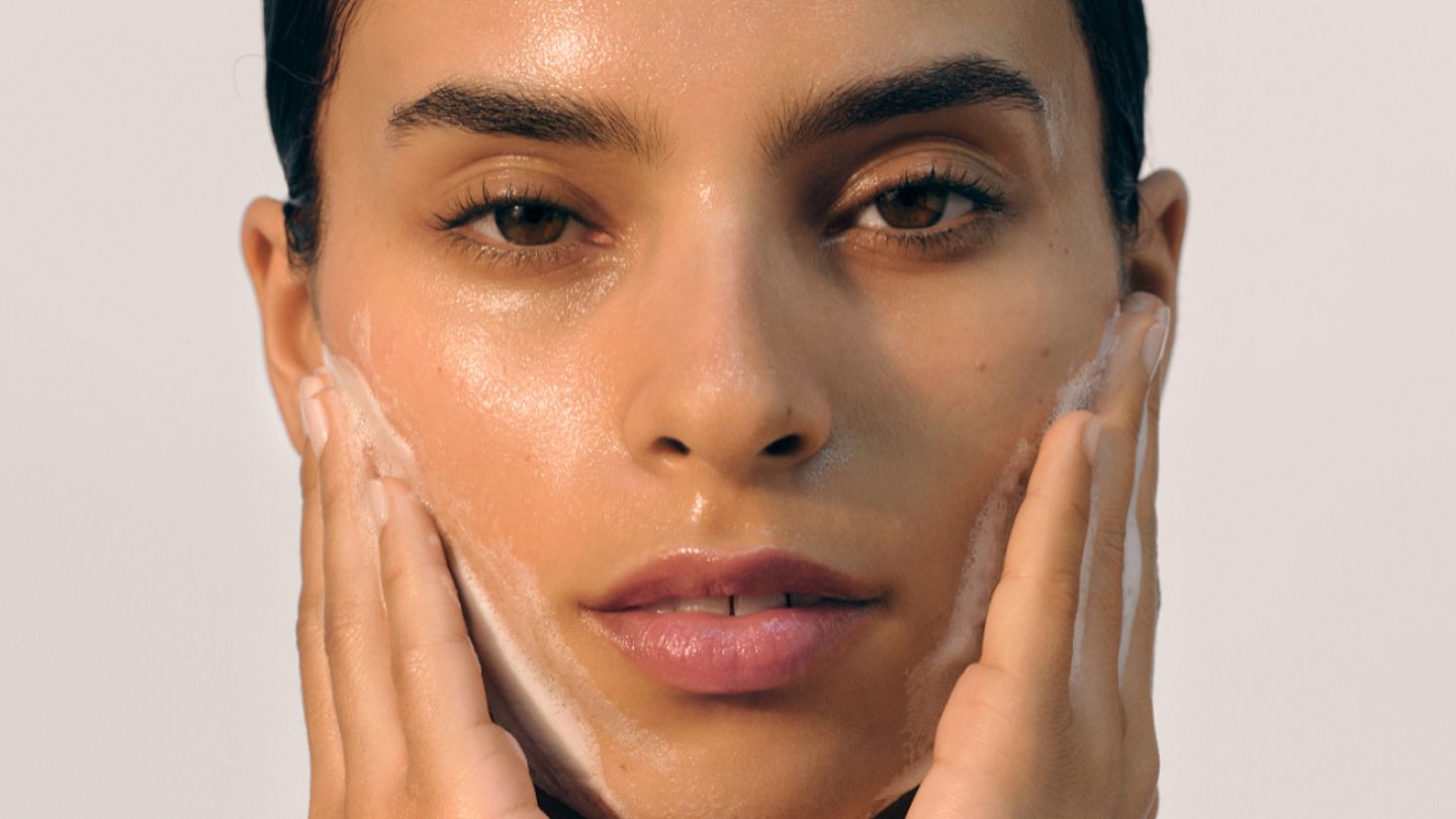 nalíčená žena myje pleť